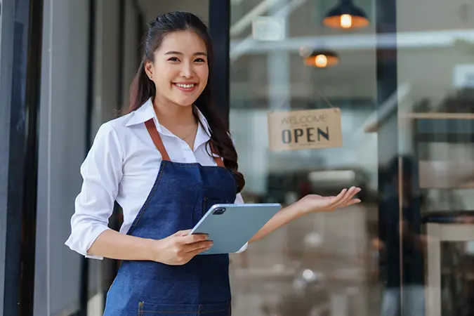 Business owner placing the open sign on her shop
