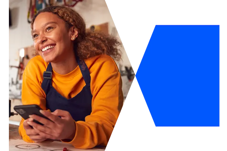Business owner smiling and holding a mobile phone